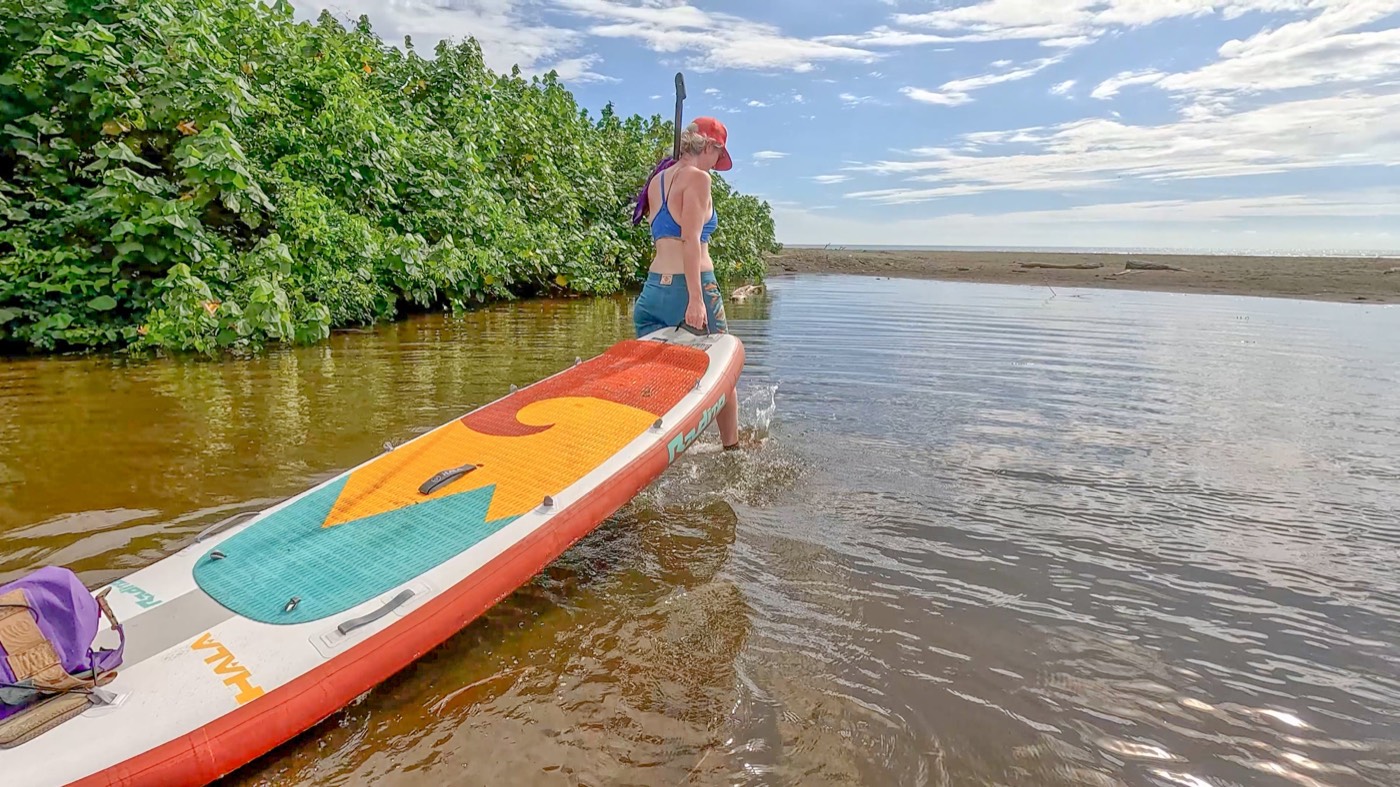Hala inflatable paddleboard on calm water beside the shore, fin and deck pad in view